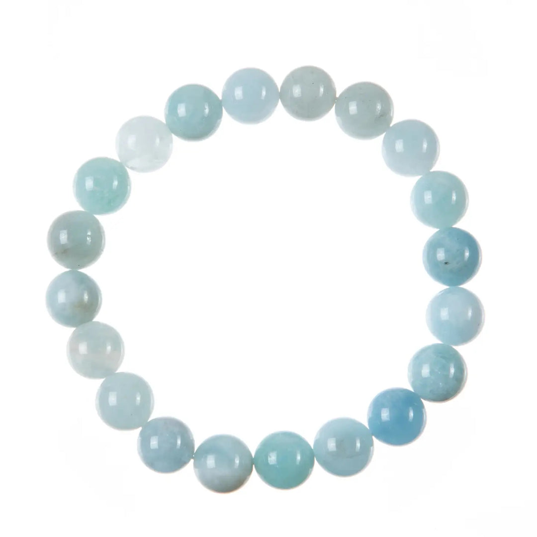 Close-up of a bracelet made with round aquamarine 10mm beads, in shades of aquamarine blue colors, and a clear stretch cord.