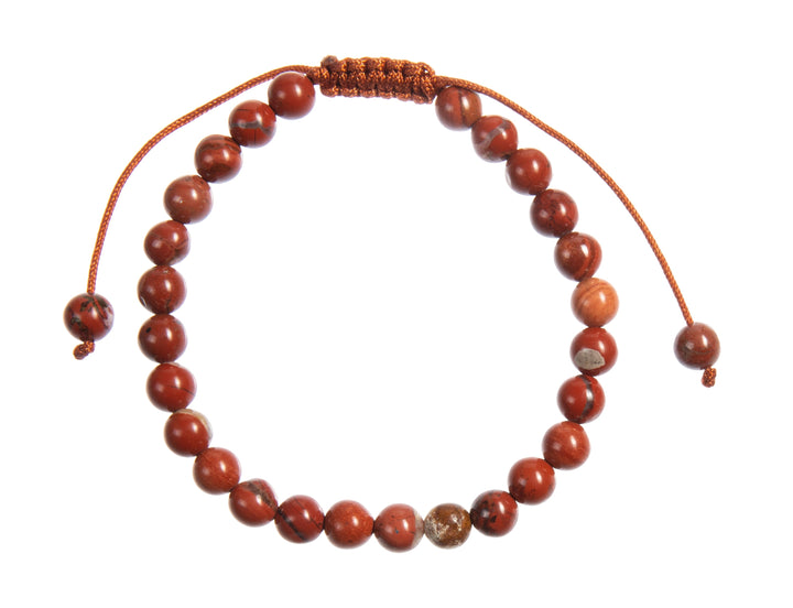 A close-up view of a carnelian bracelet, with 6mm round polished reddish orange with specks of black beads, and a reddish orange adjustable pull-tie closure, on a white background.