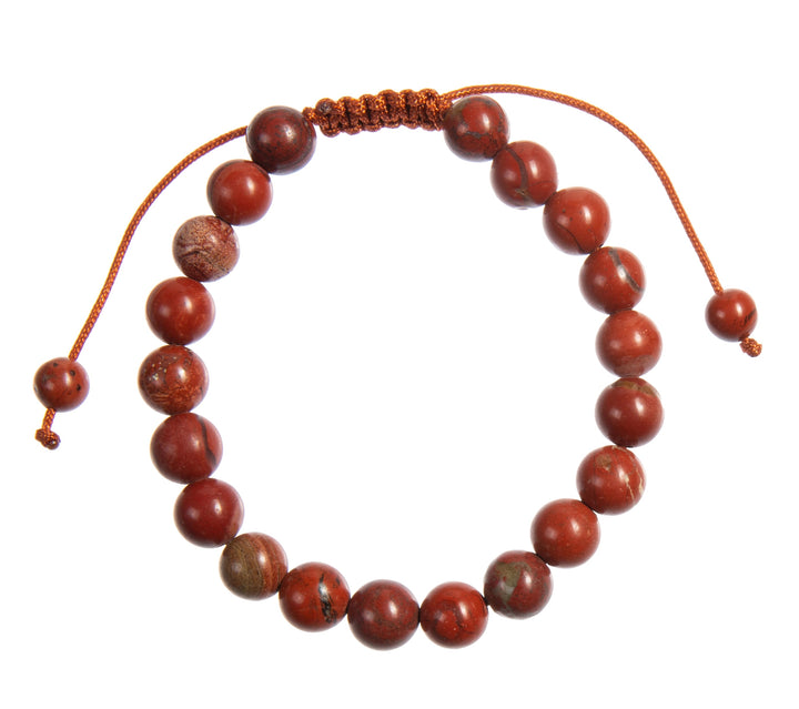 A close-up view of a carnelian bracelet, with 8mm round polished reddish orange with specks of black beads, and a reddish orange adjustable pull-tie closure, on a white background.