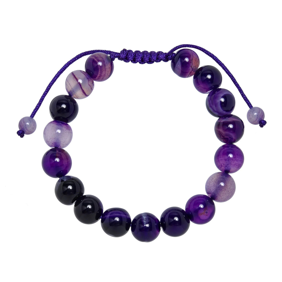 Close-up of a dog teeth amethyst bracelet made with 10mm round beads with shades of purple, and white colors, and a purple pull tie style cord closure, displayed on a white background.