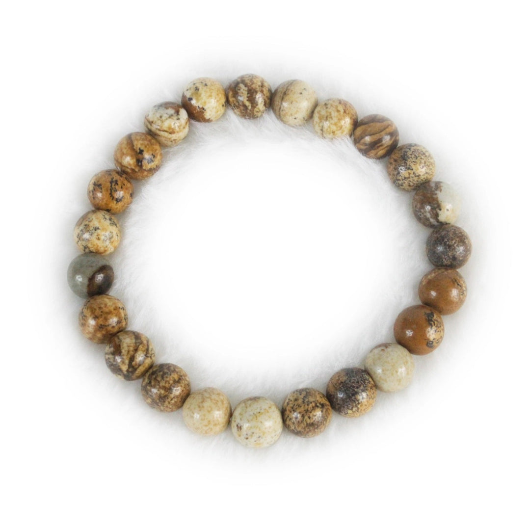 Close-up of a stretch style bracelet made with round 8mm polished picture jasper beads in shades of brown, tan, and white, displayed on a white background.