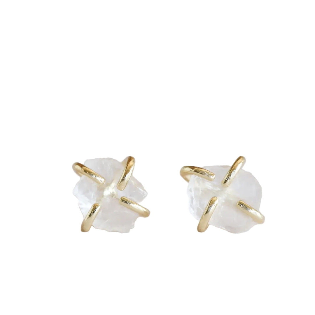Pair of stud type earrings with gold prongs and white clear quartz center stone, on a white backgroud.