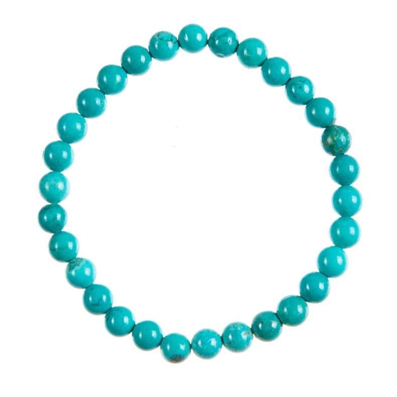 Close-up of a teal turquoise colored bracelet bracelet made with cracked turquoise 6mm beads on a clear stretch cord, displayed on a white background.