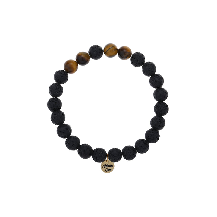 Close-up of a stretch style lava stone and tiger's eye bracelet made with 8mm round black lava stone beads with four 8mm tiger's eye beads on each side of one black center bead, in black and brown colors, with an 18k gold plated logo tag engraved with Sakora Linn, displayed on a white background.
