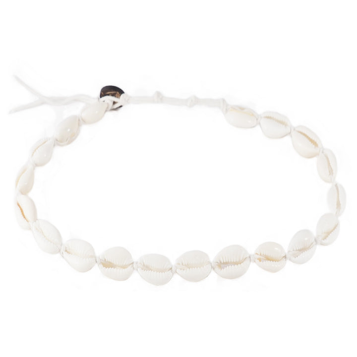 Close-up of a bracelet made with white cowry sea shells, strung on an adjustable white cord with a coconut shell button closure, displayed on a white background.