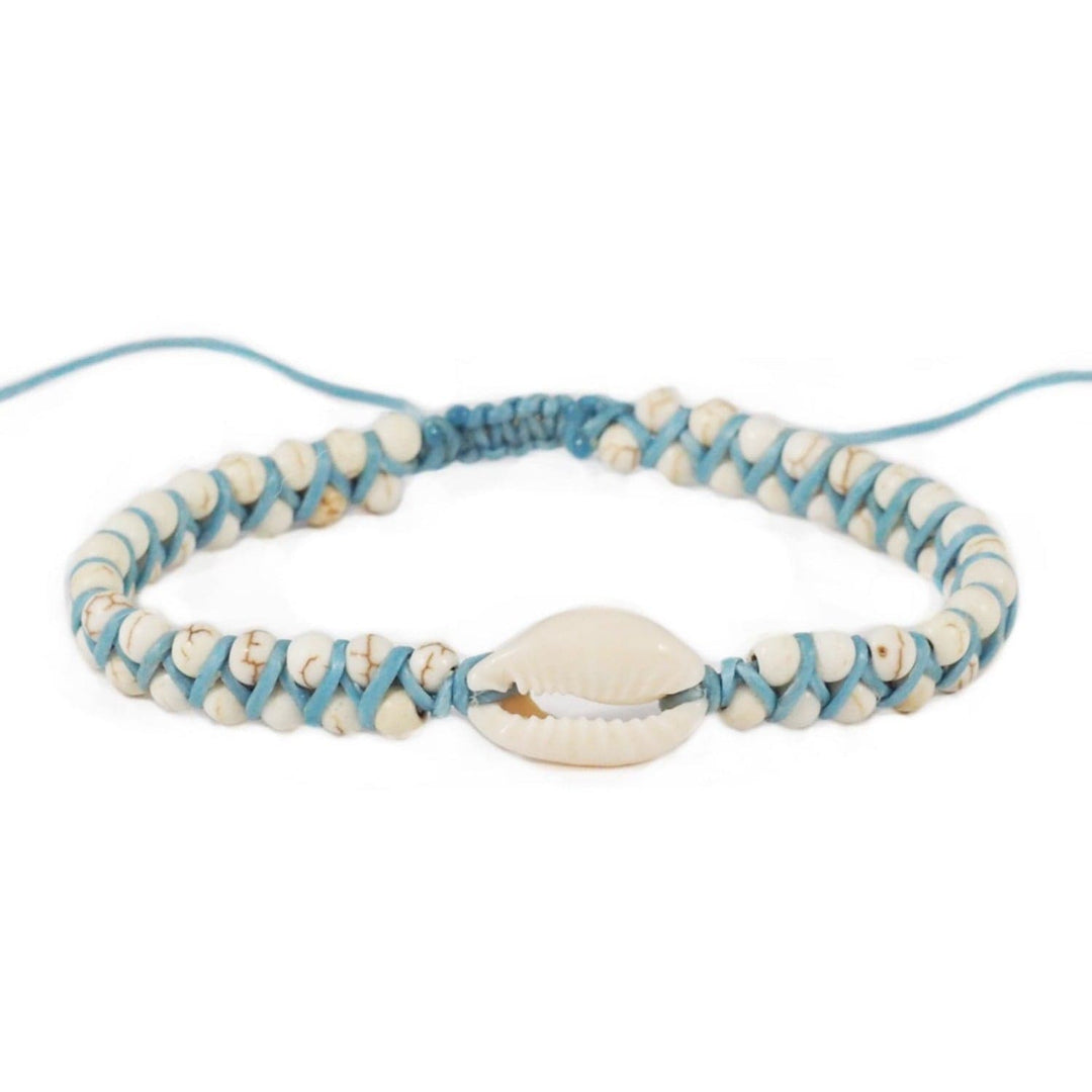 Close-up of a macrame cuff stye bracelet with white and tan marbled imitation howlite beads and a white cowry shell in the center, with a blusih gray cord and slip knot closure, displayed on a white background.