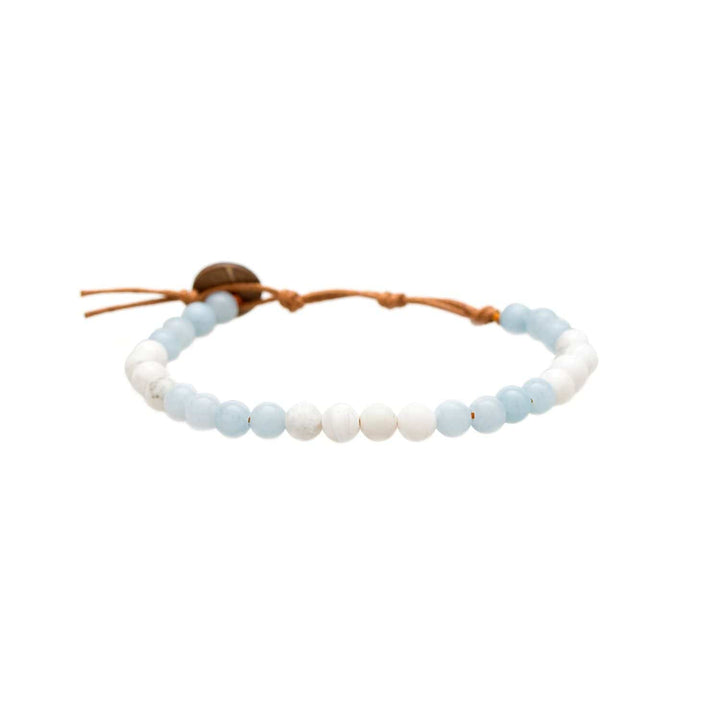 Close-up of a healing bead bracelet made with 6mm howlite and amazonite beads, in pastel blue and white colors, with an adjustable brown cord with a dark brown coconut shell button closure, displayed on a white background.