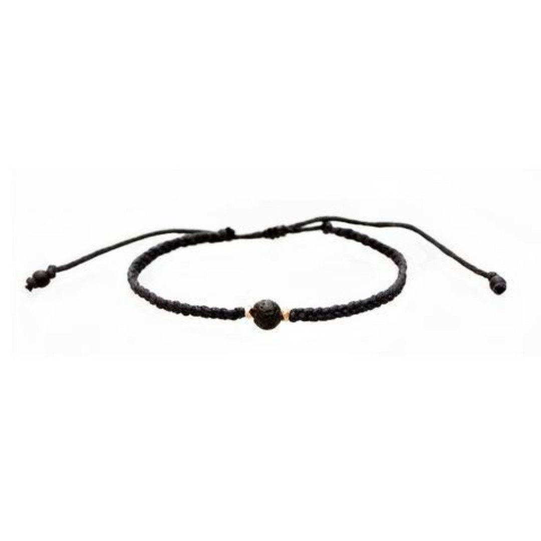 Close-up of a black bead bracelet made with black braided slide knot cord, a lava stone center bead, with gold accent beads, displayed on a white background.