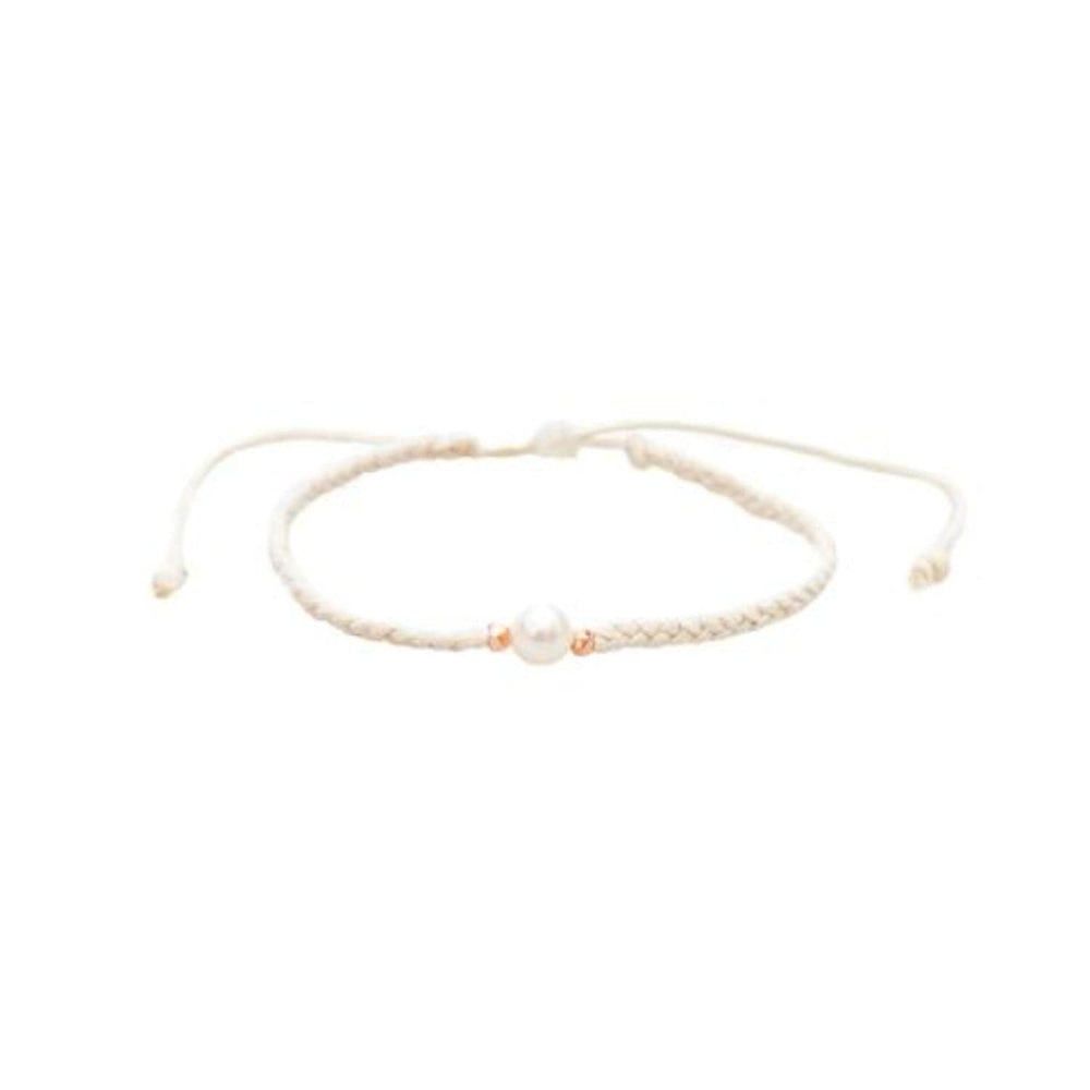 Close-up of a braided slip knot syle bracelet with a fresh water pearl bead in the center and two rose gold accent beads on each side, displayed on a white background.