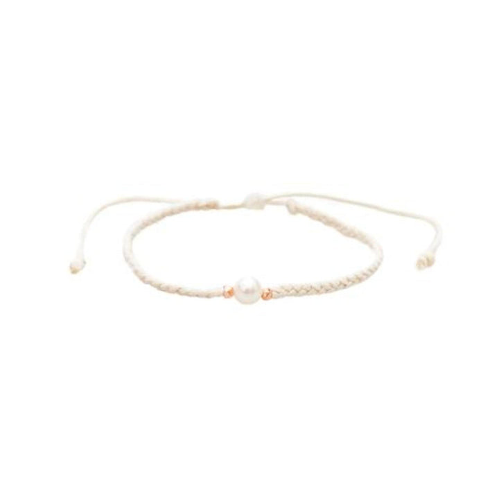 Close-up of a braided slip knot syle bracelet with a fresh water pearl bead in the center and two rose gold accent beads on each side, displayed on a white background.