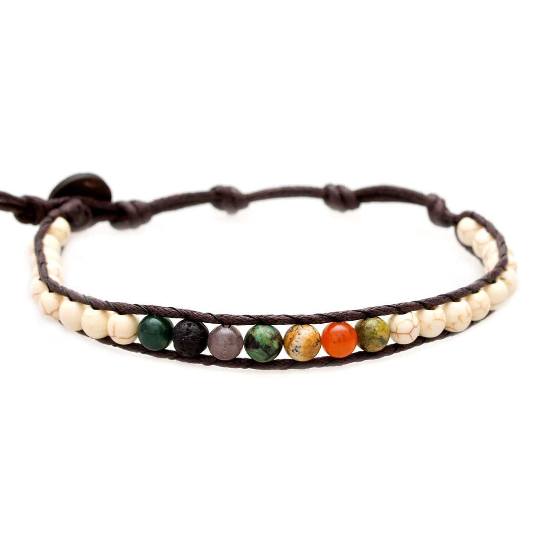 A multicolored beaded bracelet with lava stone and jade, in shades of creamy white, green, and black, featuring an adjustable brown cotton cord, displayed on a white background.