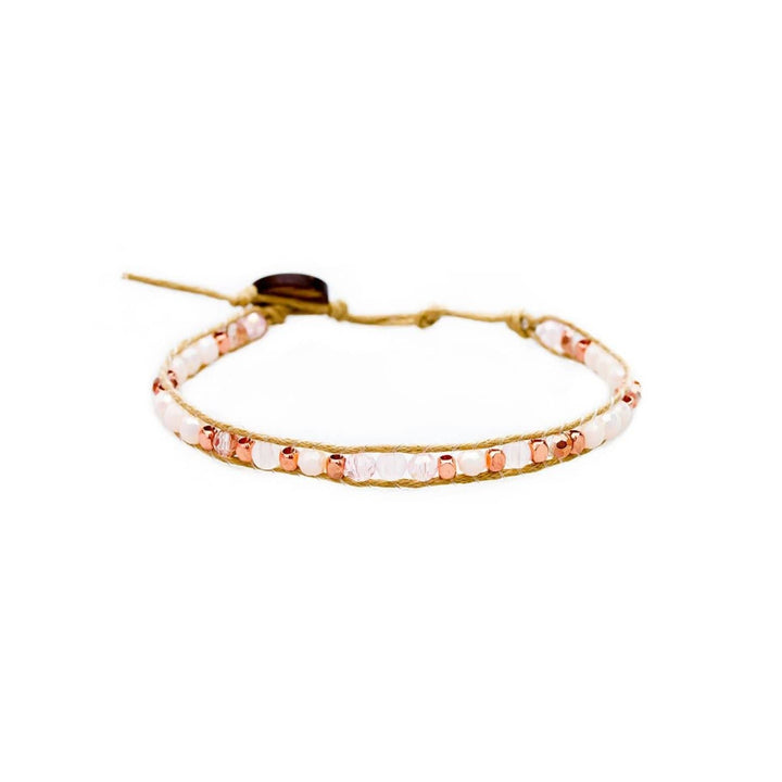 Close-up of a wrap bracelet with rose gold, copper, pink, and clear beads, a tan adjustable cotton cord with a coconut button closure, displayed on a white background.