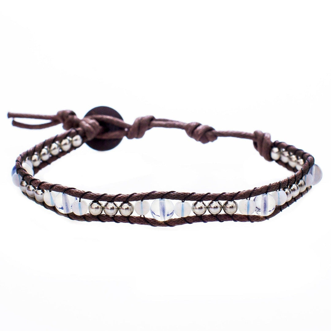Close-up of a moonstone bead wrap bracelet, with clear moonstone beads, silver accent beads, and adjustable brown cord with a coconut button closure, displayed on a white background.