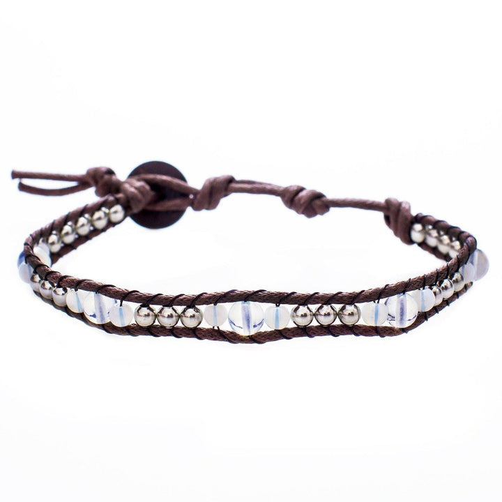 Close-up of a moonstone bead wrap bracelet, with clear moonstone beads, silver accent beads, and adjustable brown cord with a coconut button closure, displayed on a white background.