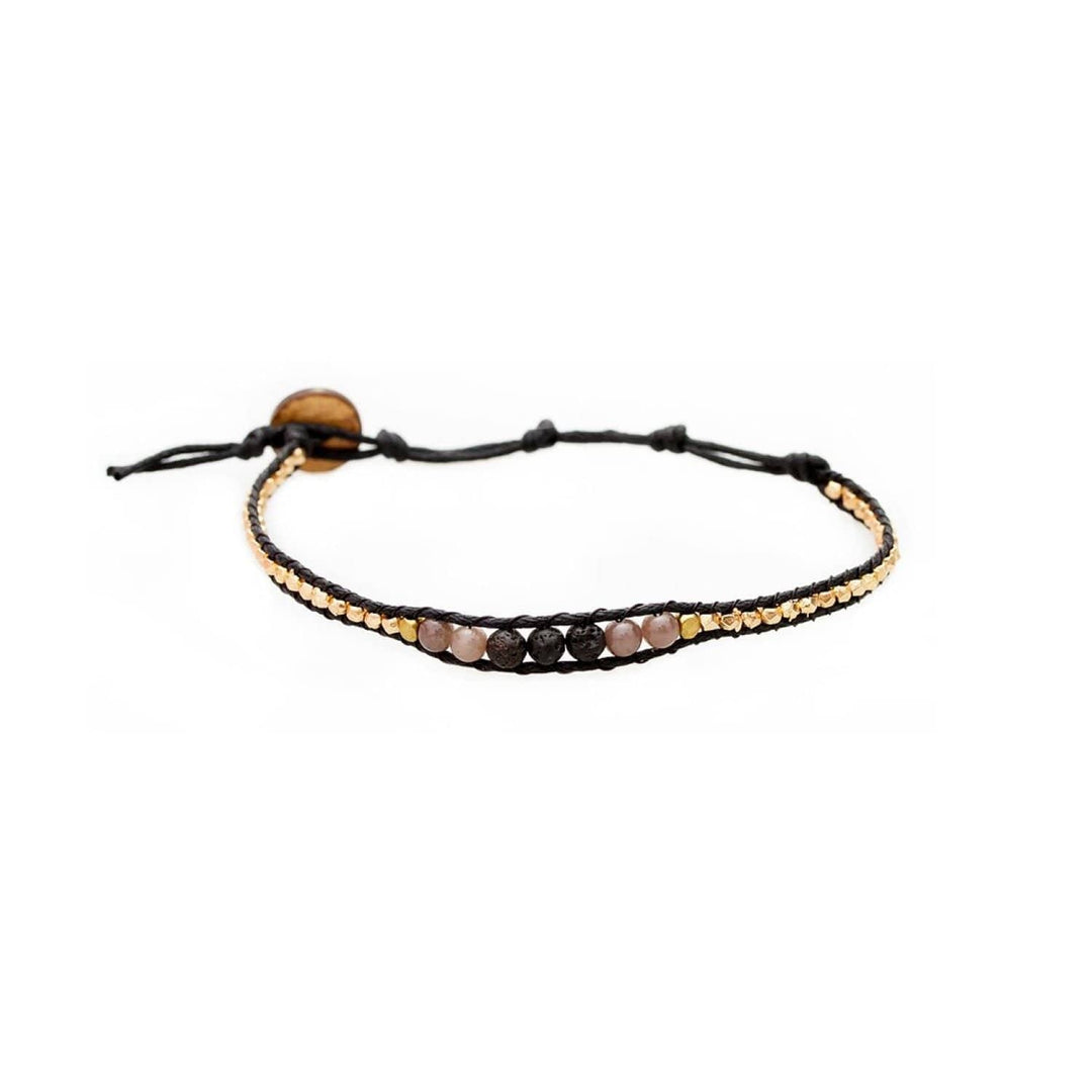 close-up of a beaded wrap bracelet with 6mm black lava stone, pink rose quartz, 4mm gold accent beads, with black adjustable cord and cocnut button closure, on a white background.