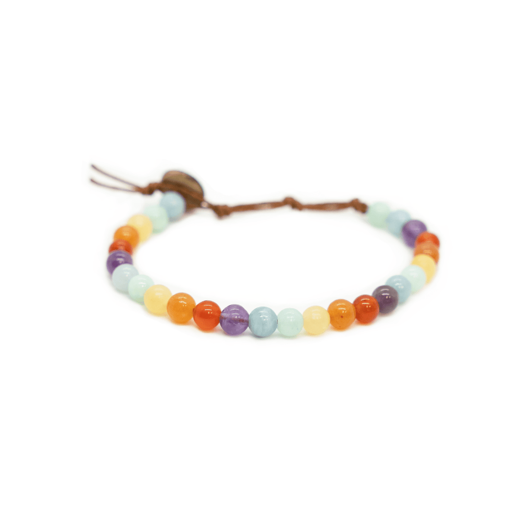 Close-up of a healing bead bracelet with round 6mm carnelian and amethyst beads in red, orange, yellow, pastel green, and purple colors, with a adjustable brown cord and dark brown coconut shell button closure, displayed on a white background.