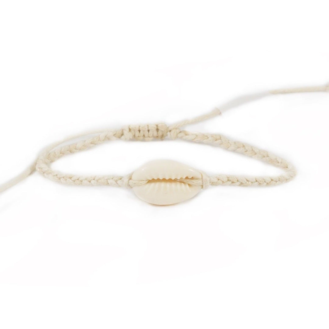 Close-up of a natural dark white braided slip knot syle bracelet with a white cowry sea shell in the center, displayed on a white background.