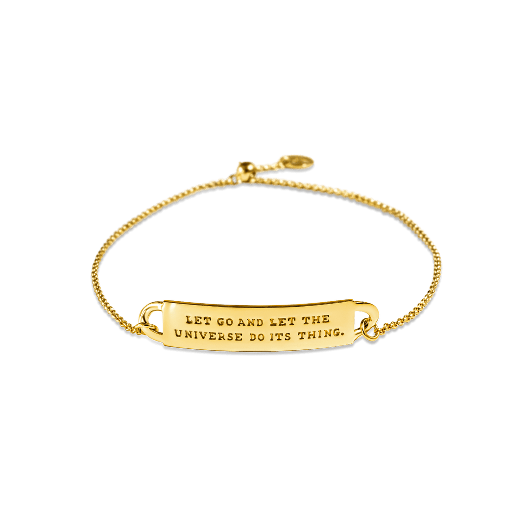 A gold-colored chain ID style bracelet with a  message band that reads 'LET GO AND LET THE UNIVERSE DO ITS THING.'