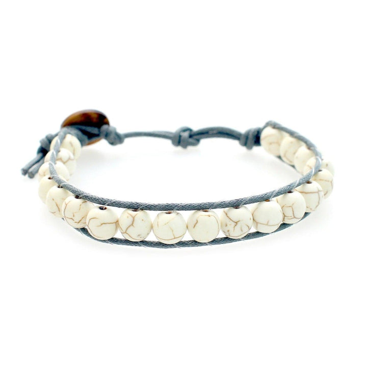 Close-up of a men's wrap bracelet with white and tan marbled howlite beads and an adjustable gray cord with a brown coconut shell button closure, displayed on a white background.