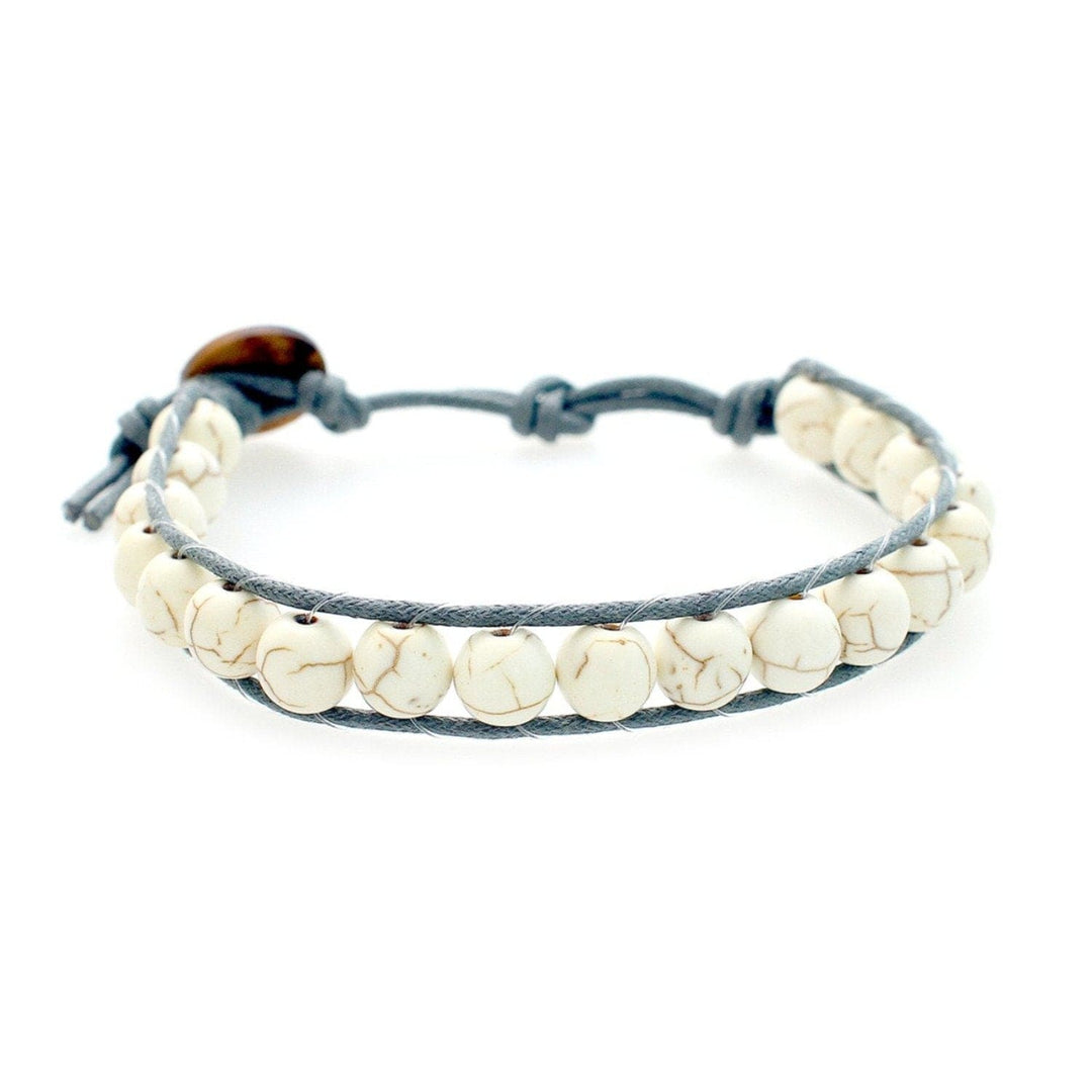Close-up of a men's wrap bracelet with white and tan marbled howlite beads and an adjustable gray cord with a brown coconut shell button closure, displayed on a white background.