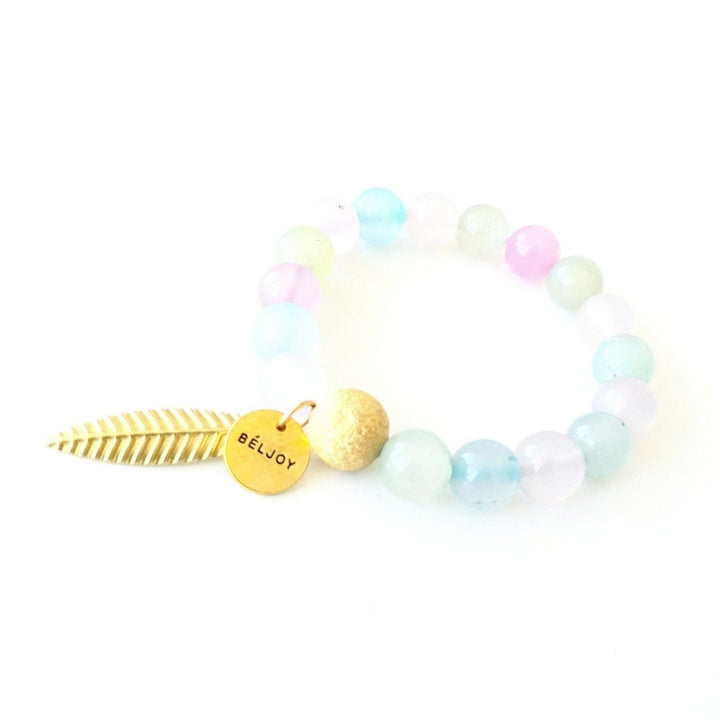 A pastel agate beaded bracelet in shades of pink, teal, and clear with a gold sparkle bead and a leaf charm, displyed on a white background.