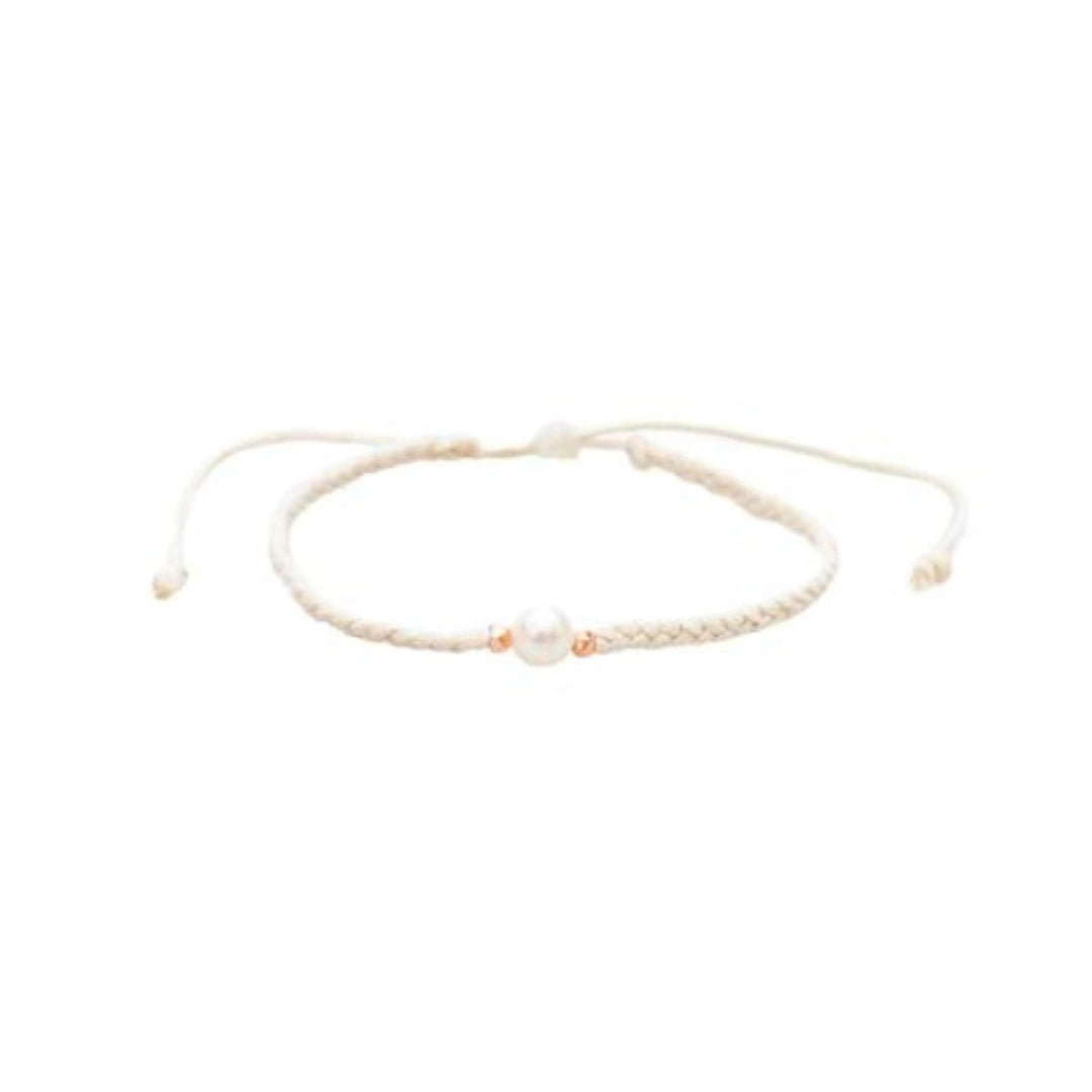 Close-up of a white braided slip knot syle bracelet with a white fresh water pearl in the center and small gold accent beads on each side of the pearl, displayed on a white background.