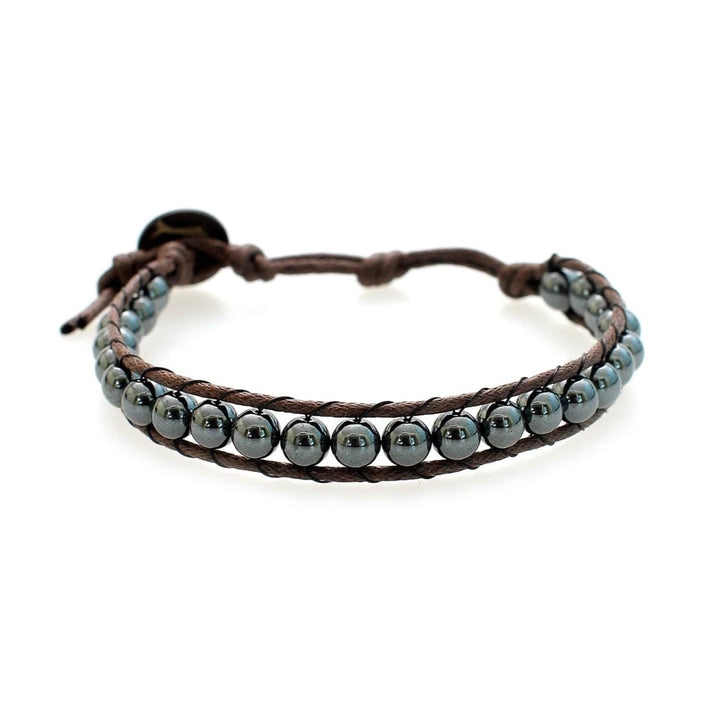 Close-up of a men's wrap bracelet made with gray hematite beads, brown adjustable ocrd and brown coconut button closure, displayed on a white background.